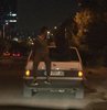 Ankara’da iki gencin seyir halindeki otomobilin bagaj kapağı üzerinde yaptığı yolculuk görenleri şaşkına çevirdi. Yoldan geçenlerin meraklı bakışlarına aldırış etmeyen gençler, kendilerini kaydeden kamerayı görünce tehlikeli yolculuklarına son verdi