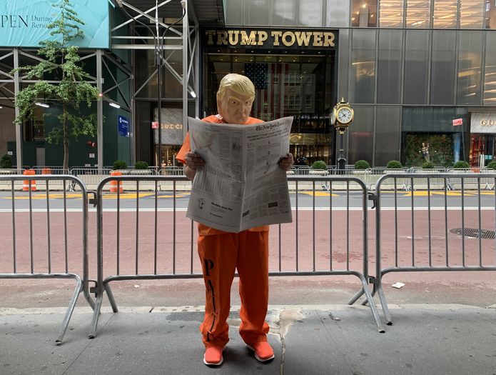 New York’taki Trump Tower’ın önüne gelen bir gösterici Trump maskesini takarak vergi haberinin yayınlandığı New York Times’ı orada okumaya başladı.