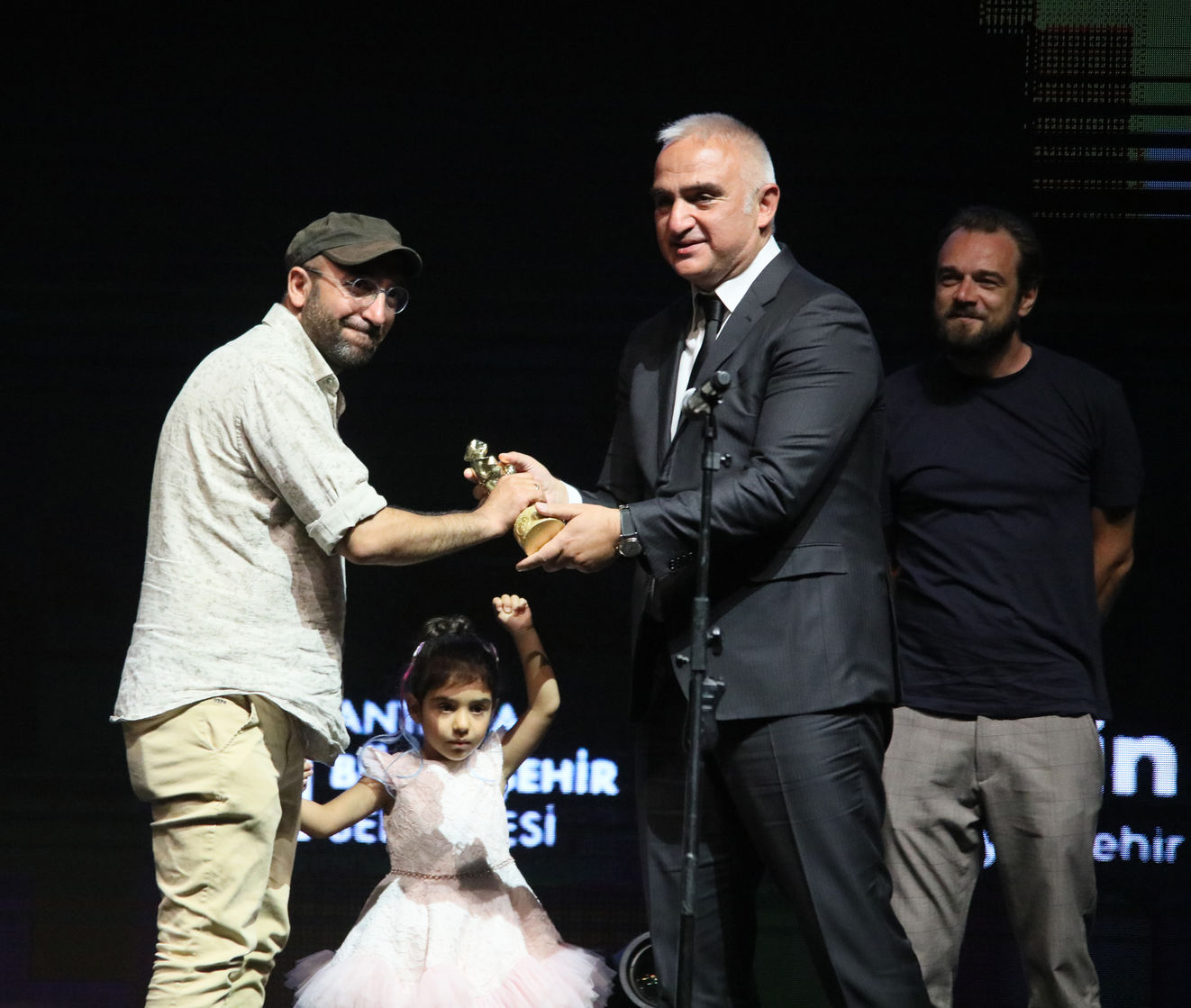 'Okul Tıraşı'nın yönetmeni Ferit Karahan, 'En İyi Film' dalındaki Altın Portakal'ı kızıyla birlikte Kültür ve Turizm Bakanı Mehmet Nuri Ersoy'dan aldı. 