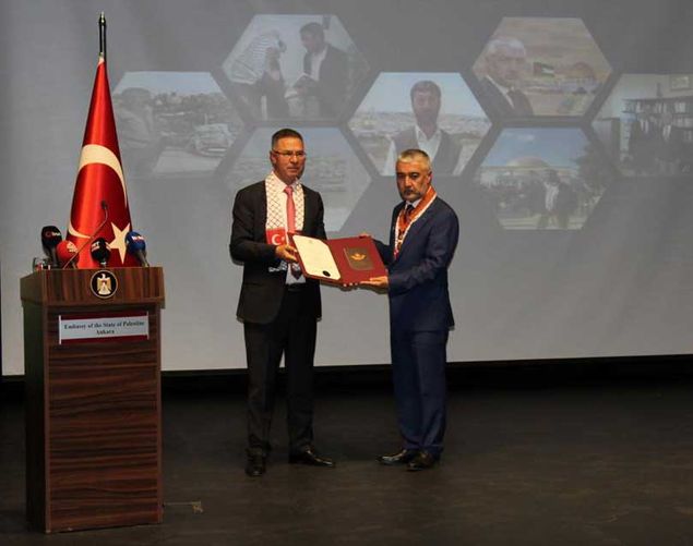 Sefer Turan (sağda), Ankara’daki törende Filistin’in Ankara Büyükelçisi Dr. Faid Mustafa’dan “Liyakat Yıldızı” nişanını alırken.