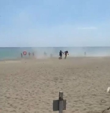 Antalya’nın Serik ilçesinde şiddetli rüzgarın oluşturduğu küçük çaplı hortum, tatilcilere zor anlar yaşattı. Sahilde kum fırtınasına neden olan hortum, şezlongları ve şemsiyeleri de savurdu