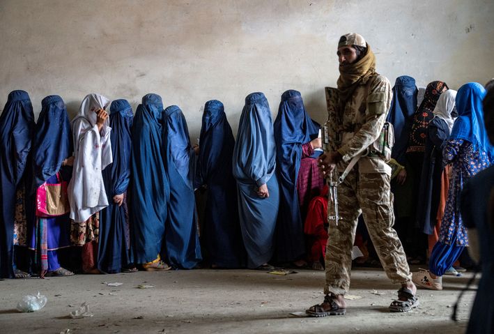 Afgan kadınları Taliban savaşçısı gözetiminde yemek kuyruğunda