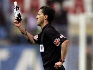 2006'da Atletico Madrid ile Sevilla arasında oynanan maçta hakem Miguel Angel Ayza sahada yerden aldığı viski şişesinin sahibini arıyor.