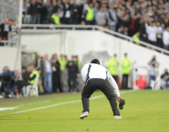 Sivasspor Teknik Direktörü Bülent Uygun Beşiktaş maçında, sahaya atılan ayakkabıyı geri yolluyor.