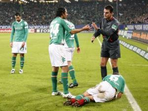 Frank Baumann yerde: Bremen kaptanı, Hamburg ile yaptıkları maçta bir taraftarın fırlattığı cep telefonu piliyle yerde kaldı.