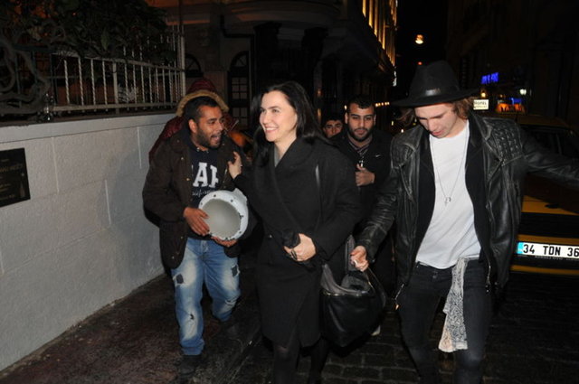 Röportaj sırasında sokak çalgıcıları anne-oğulun etrafını sardı ve bahşişistedi. 