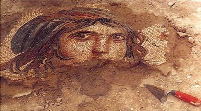 Mozaiğe, albenisi ve diğer bölümlerinin olmaması anlam kazandırdı. Öykünün eksik olmasının, ziyaretçilerin kendilerine göre sanal tamamlama yapmalarına yol açtığı öne sürülüyor. Çingene Kızı mitoloji sözlüklerinde yer almıyor. İnsan figürünün Büyük İskender olduğunu ifade eden birçok arkeologun yanı sıra, Yer Tanrısı Gaia olduğunu savunanlar da var. Pierre Grimal'in Mitoloji Sözlüğü'nde, Yer Tanrısı Gaia, içinden tanrı soylarının çıktığı ilk element kabul ediliyor.