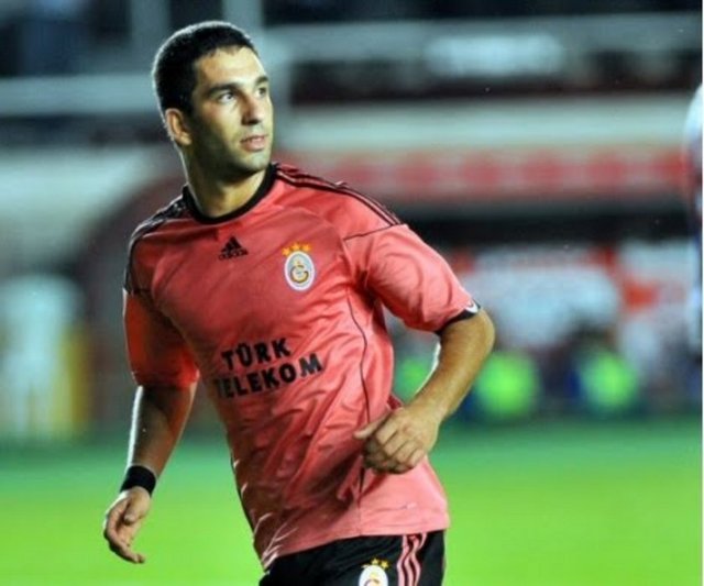 Arda Turan'ın somon rengi formalar için söylediği söz: (Adnan Sezgin'e) Şu formalara nasıl bakmazsın? Her sene bir or... rengi var. Heriflere malzeme veriyoruz.