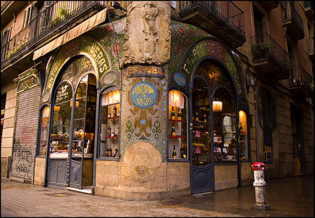 Pasteleria Escriba Barselona: Pasteleria Escriba Barcelona La Rambla'da, 1906 yılında açıldığından bugüne muhteşem güzellikteki Art Nouveau binasında hizmet vermeyi sürdürüyor. Modern iç dizaynıyla da eski ve yeniyi buluşturmayı başaran pastanenin tatlılarını açık havada yemek isteyen müşterileri için terası bulunuyor. Aileden gelen gelenekle Barselonalılar'ın ve gelen turistlerin kalbini eriten lezzetler sunan pastanenin İspanyollar'ın ferredura diye adlandırdığı at nalı şeklinde ananaslı ve çam fıstıklı kurabiyeleri, kekleri ve çikolataları en beğenilen tatlıları arasında.