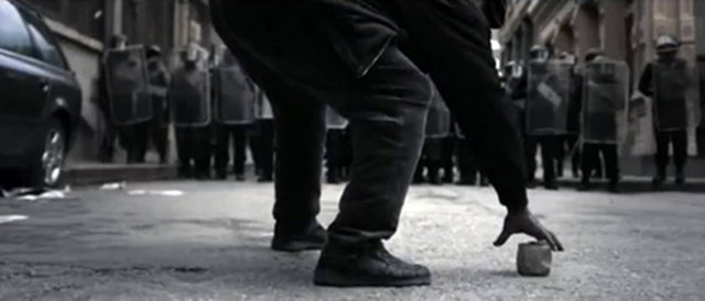 Bu reklam tartışma yarattı!Reklamda polislere atmak için yerden taş alan bir adamın yer alması normal olarak gösteriliyor.