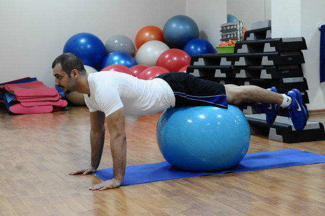 4-Pilates topunun üzerine ellerimizi yere 90 derece acıyla dik bir şekilde göğsümüzü aşağı yukarı iterek göğüs kasları,arka kol ve omuz kaslarımızın sıkılaşmasını sağlayacaktır.