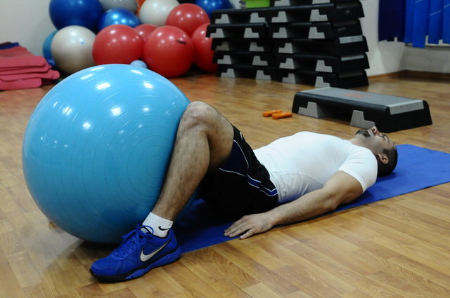 5-Sırt üstü yere uzanıp dizlerimizi kırıyoruz ve pilates topunu bacaklarımızın arasında sıkıştırarak iç bacak kaslarımızın çalışmasını sağlıyoruz.