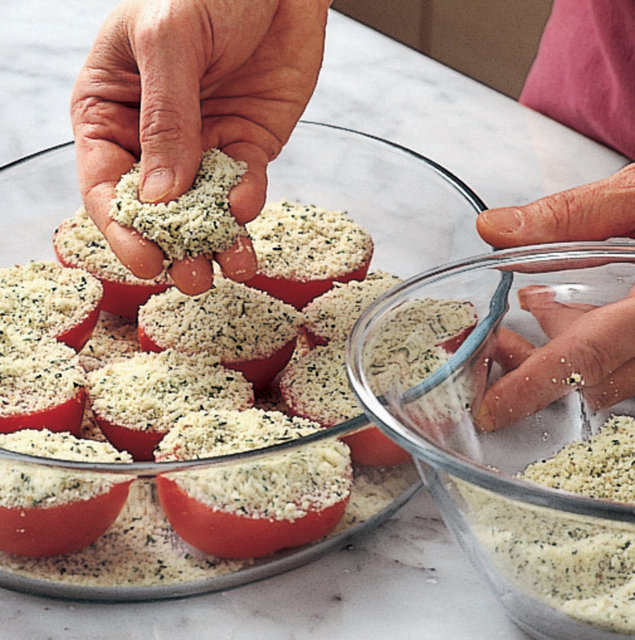 9. Provensal usulü domates yaparken domateslerin üzerini gratine yapmak için, pane harcına doğranmış taze baharat, rendelenmiş parmesan peyniri ve ezilmiş sarımsak ekleyin.