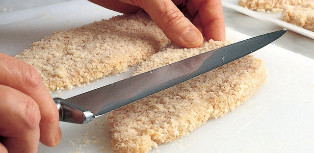 6. Pane harcına bulanmış etin üzerindeki kırıntıların toparlanması ve fazlalıklarının elenmesi için eti bir bıçak veya spatula ile sıkıştırın.