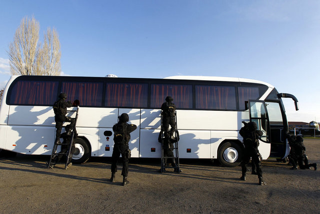 Keskin nişancıların desteklediği tim üyeleri gizlice otobüsün çevresini sarıyor.