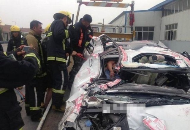 Üzerine konteyner düşen bir otomobilin içinde bulunan iki kişi adeta preslenmiş gibi dümdüz olan aracın içinden mucize eseri sağ çıkmayı başardı.