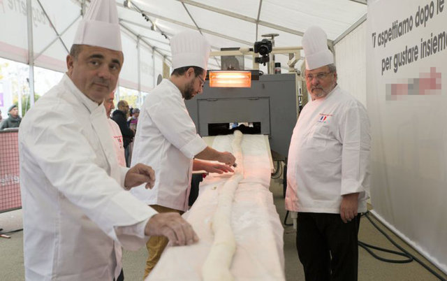 Soğuduktan sonra 2 bin 400 dilime bölünen ve yaklaşık 400 adıma denk gelen ekmek, üzerine kakaolu fındık kreması sürülerek ziyaretçilere ikram edildi.