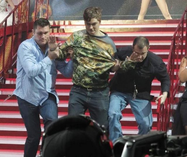 Bu hareket karşısında neye uğradığını şaşıran genç şarkıcı gülümsemekle yetinirken, görevliler sahneye çıkan adamı apar topar aşağıya indirdi.