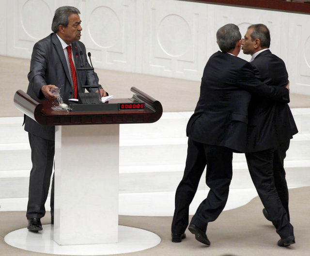 O sırada kürsüdeki su dolu bardağı alan Genç, Aslan'a fırlatacakmış gibi yaptı. Ancak su yaşanan arbede sırasında Genç'in üzerine döküldü.