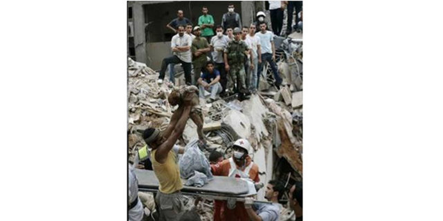 AFP -  - Lübnanlı bir genç İsrail kuvvetleri tarafından bombalanan binanın yıkıntılarından çıkartılan bebeği tutuyor...