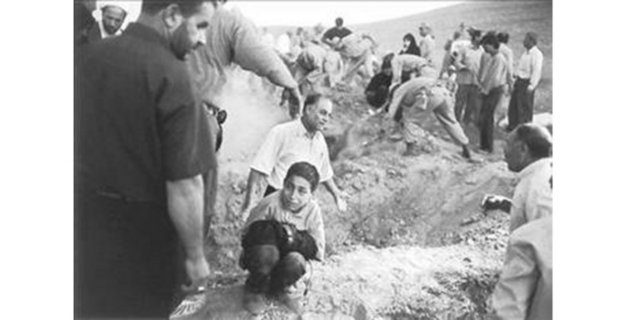 2002 Eric Grigorian, ABD -  - İran'da asker ve köylüler, depremde ölen kurbanlar için mezar kazıyorlar. Bir çocuk ise ölen babasının pantolonuna sıkı sıkı sarılmış, yanıbaşındaki boşluğa babasının gömülmesini bekliyor...