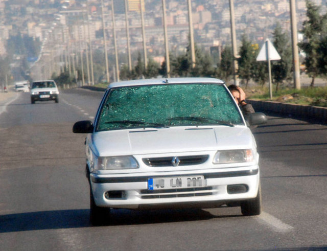 Aracının ön camı kırılan sürücü, yolu görebilmek için trafikte kafasını yan camdan çıkardı