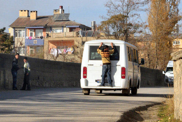 Minibüsün arkasına asılarak yolculuk yapan çocuklar tehlikeye aldırmadan kaçak olarak sürdürdükleri yolculuklarına devam ediyorlar