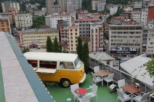 Mustafa BAYRAK / HT GAZETE Rize'deki bir plazanın terasında bulunan cafeyi işleten Özay Topuk, yaz aylarındaki bar ihtiyacını karşılamak için 11. kata minibüs çıkardı.