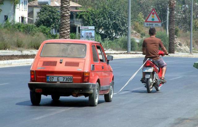 Antalya'nın Alanya ilçesi'nde arızalanan aracı ip bağlayarak motosiklet ile çeken kişi görenleri hayrete düşürdü