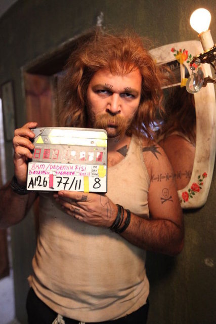 Peruğu, sakalı ve dövmeleriyle bambaşka bir kimliğe bürünen Sunal'ın değişimi saatler süren makyajla gerçekleştirildi.