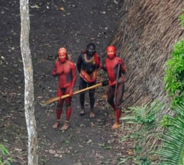 Fotoğraflarda ilk kez bu kadar yakından ve detaylı görüntülenen kabile üyeleri, yüzlerindeki kırmızı boyalar, mızrakları ve yaylarıyla adeta başka bir dönemden gibi görünüyorlar.