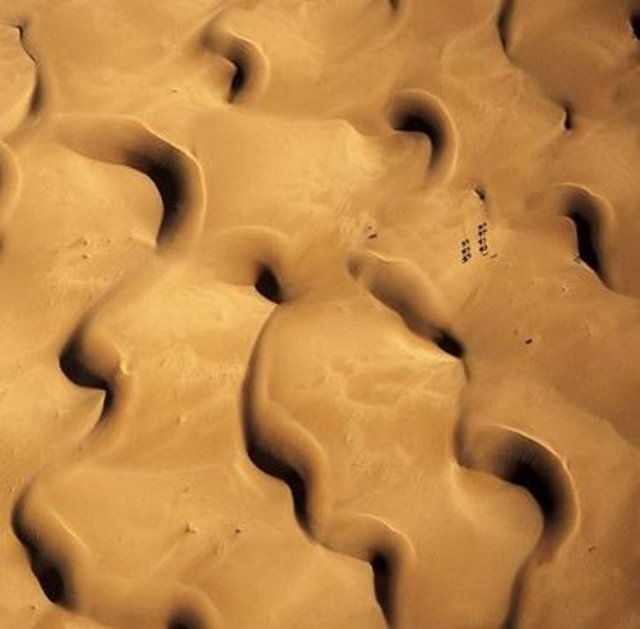 Sahra Çölü'nün Moritanya'daki bölümünde turistler, eski bir kervan yolunda ilerliyor. Kum fırtınaları kumulları durmaksızın hareket ettirerek sürekli değişen bir görüntü yaratıyor.