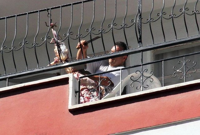 Kurbanlığını balkon tavanına asarak derisini yüzen şahıs, görenleri hayrete düşürdü. -