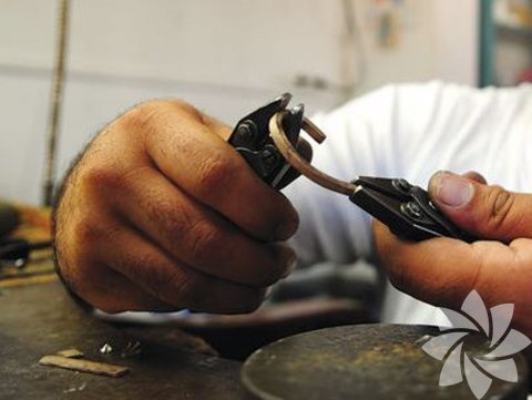 Yatay çubuk haline getirilen altın parçası, ateşle yumuşatılarak penseyle kıvrılıp halka haline getiriliyor.