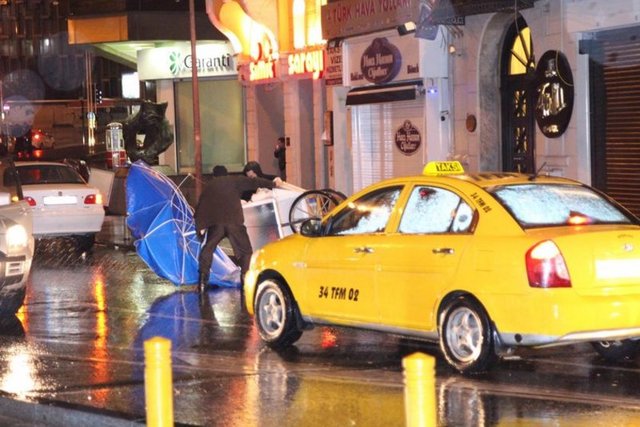 Taksim'de kısa sürede yol kenarlarında su birikintileri oluştu. Yağmur ve rüzgar vatandaşlara zor anlar yaşattı.