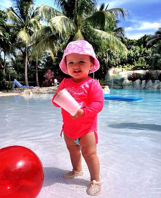 Küçük kız annesiyle birlikte kuaför koltuğunda. Annesi saçlarını yaptırırken bir görevli de onun tırnaklarını törpülüyor. -