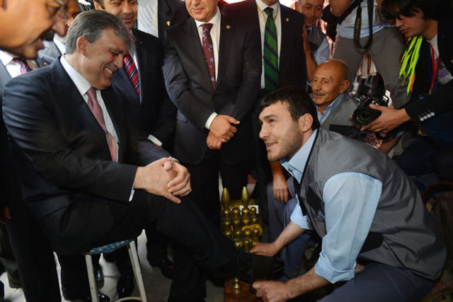 Cumhurbaşkanı Gül, Kayseri'de Cuma Namazı çıkışında, cami etrafında bulunan boyacılardan birinde ayakkabılarını boyatıyor.