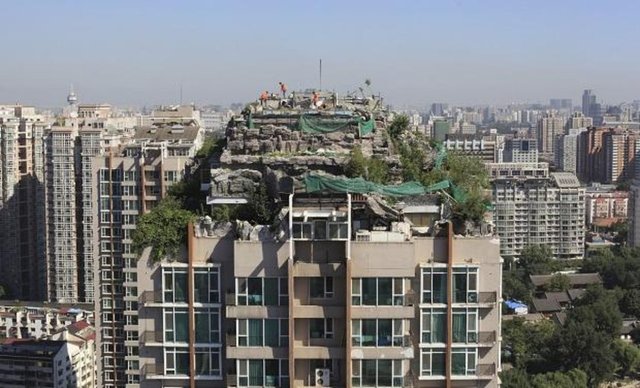 Çin'de 26 katlı apartmanın üstüne inşa edilen taş ev.