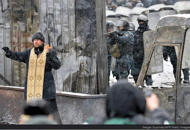Bir Ortodox rahibi şiddetli çatışmaları durdurmaya çalışırken.
