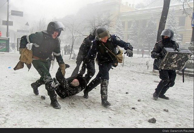 Polisler Avrupa yanlısı bir göstericiyi yakalayıp götürürken.