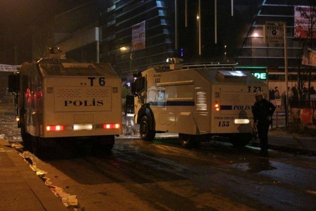 Protestocu grubun attığı havai fişekler nedeniyle zor anlar yaşayan polisler, TOMA'nın arkasına geçerek korunmaya çalıştı.