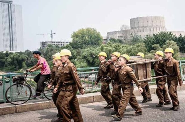 Köprü üzerinde uygun adım giden inşaat işçileri