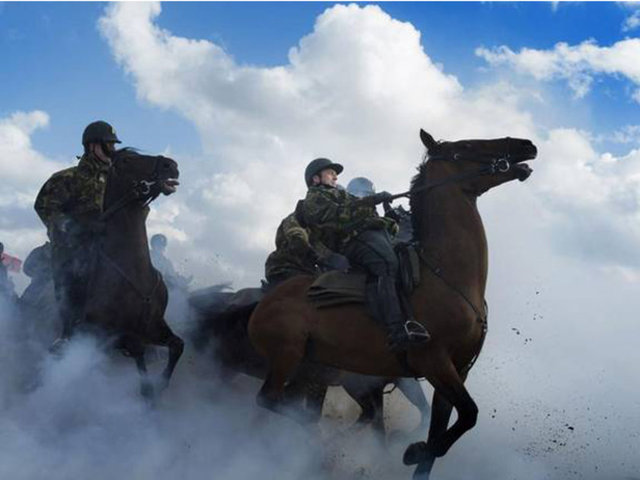 Kraliyet Muhafızları Hollanda askerlerini genelde hayvanlarla yetiştirmek istiyor. Fotoğrafta, askerler duman bombalarının içerisinde atlarını sürmeye çalışıyorlar.