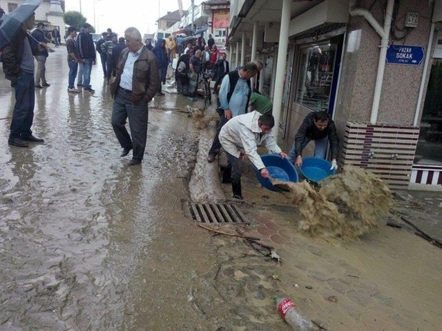 Cumayeri'nde yaklaşık 50 işyerini su basarken, esnaflar kovalarla işyerlerindeki suları boşaltarak temizlik yaptı.