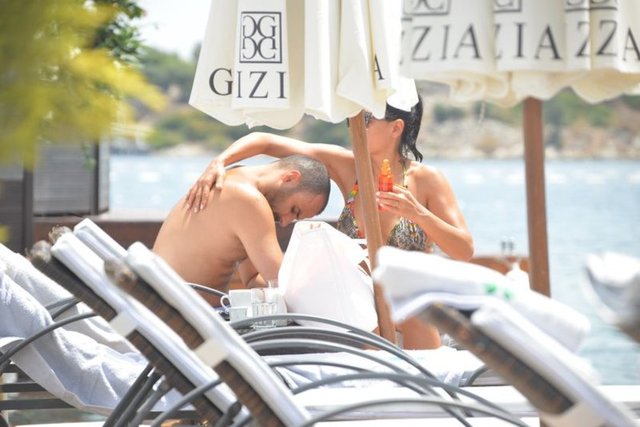 Güneşten zarar görmemek için temkinli davranan Soydaş, işadamı eşi Cem Pole'un sırtına sık sık güneş kremi sürdüğü görüldü.