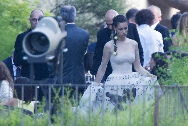 İtalya'nın Monterotondo'da gerçekleşen törende, manken Pellegrinelli, üzerinde sevdikleri aşk şarkısının notaları yazılı olan krem rengi bir gelinlik giydi.