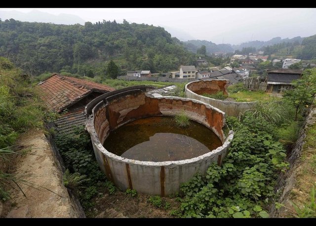 Artık kullanılmayan bu su tankı, Heshan köylülerini bu hale getiren kükürtlü arsenik madenlerinden birine ait.