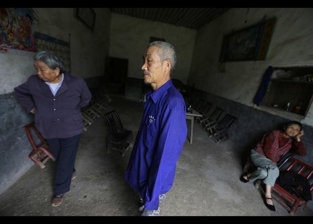 Rahim ağzı kanseri olan komşuları Gong Zhaoyuan, Gong ve karısı Wu Qunyao'nun (solda) evini ziyaret ediyor. -