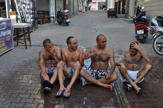 Akşam için hazırlıklara başlamaları nedeniyle deniz veya havuza gidecek zamanları olmayan çalışanlar, hortumla serinlemeyi seçti.