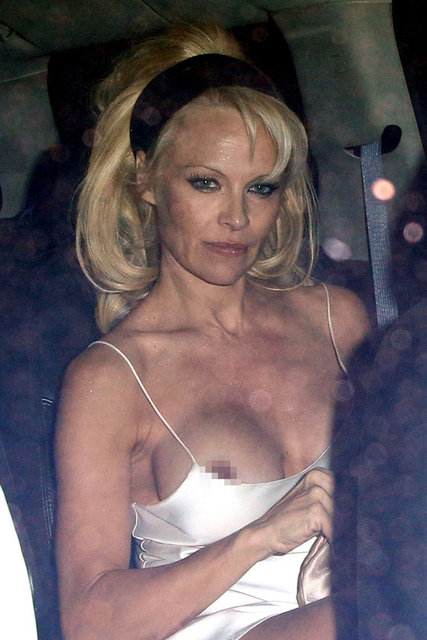 Üzerinde geceliğe benzer tülden bir elbise olan Anderson'ın göğüsleri olduğu gibi elbisenin dışındaydı.